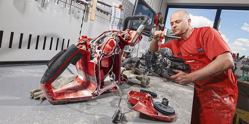 image of a man in red overalls fixing a hilti tool