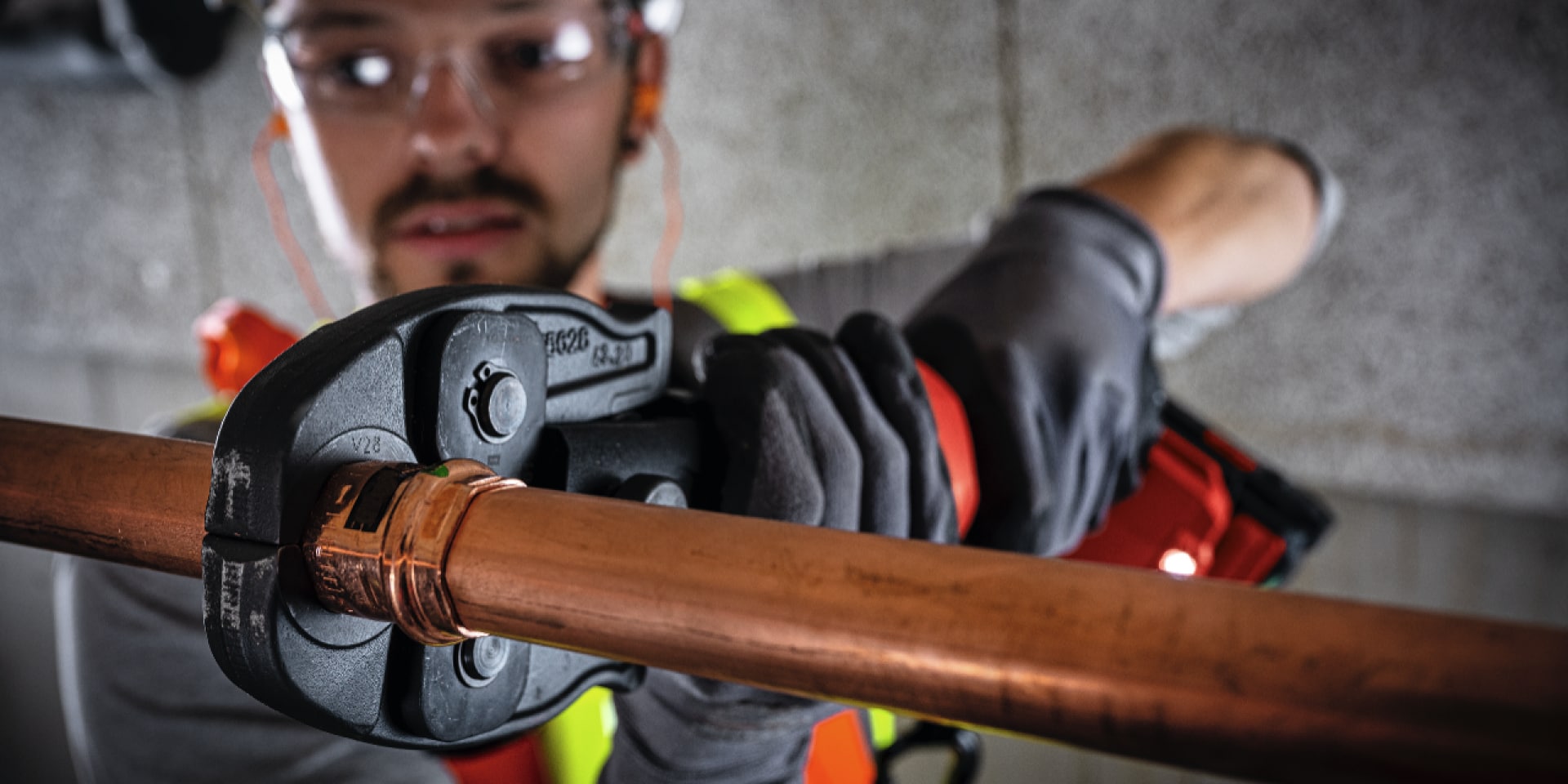 person using a pipe press tool